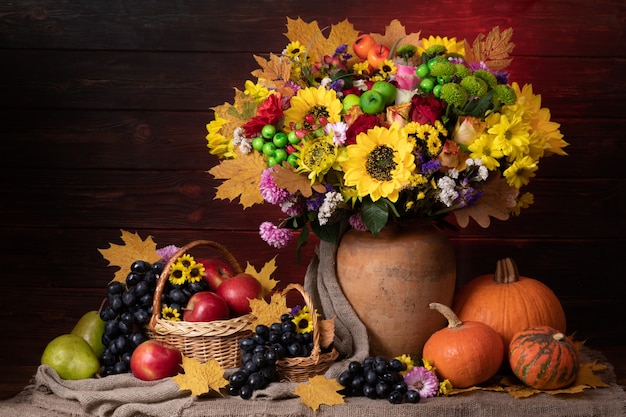 Autumn still life with leaf, sunflowers, pumpkin and fruits.