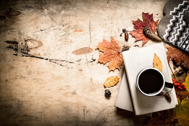 Autumn style. Coffee with an old books. On wooden background.