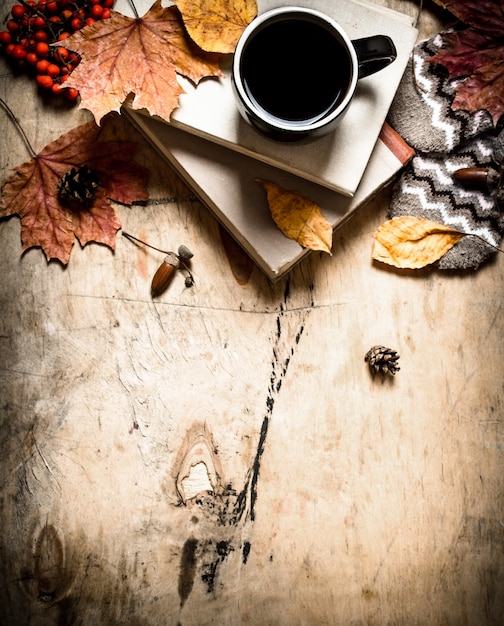 Autumn style. Coffee with an old books. On wooden background.