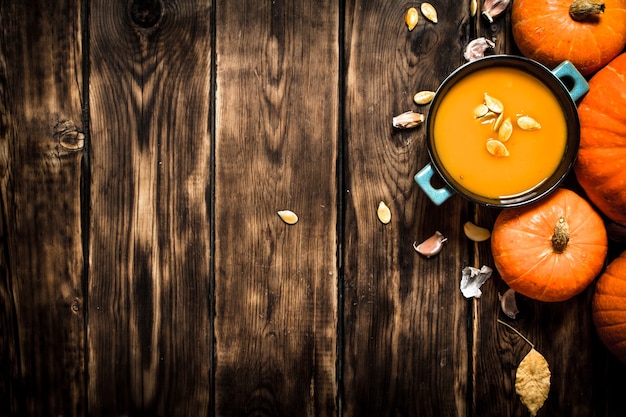 Autumn style Fresh pumpkin soup on wooden background