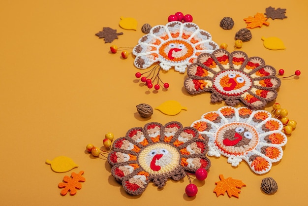 秋のテーブルセット 感謝祭の食器 伝統的な秋の装飾 フラットレイ フェスティバルの居心地の良い ハンドメイドの crocheted トルコと葉 硬い光 暗い影 コピースペース