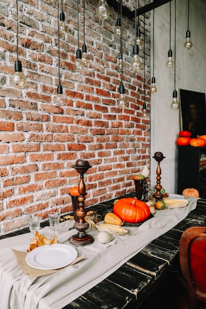 Autumn table with pumpkins and candles for festive dinner