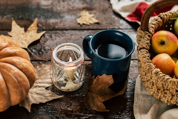 Autumn, tea, pumpkins and apples on a wooden table