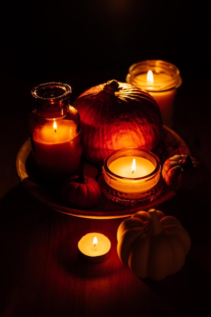 Autumn thanksgiving home decor with pumpkins and burning candles on table dark moody banner