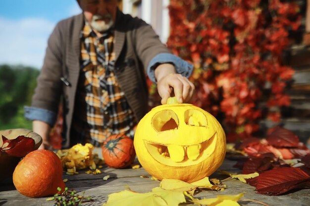 写真 秋の伝統と休日の準備ハロウィーンカボチャで作られたランプがテーブルで切り取られている自然の家