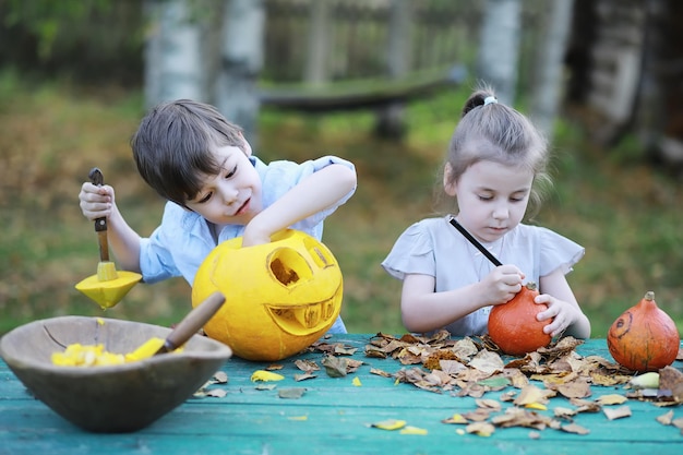 秋の伝統と休日のハロウィーンの準備。自然の中の家、カボチャで作られたランプがテーブルで切り取られています。