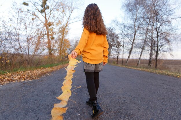 Autumn walk girl with yellow leaves girl walks in autumn