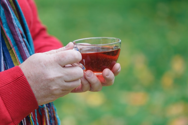 Autumn walk in park with cup of tea