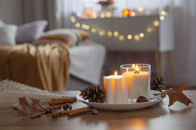 Photo autumn and winter home decor with burning candles