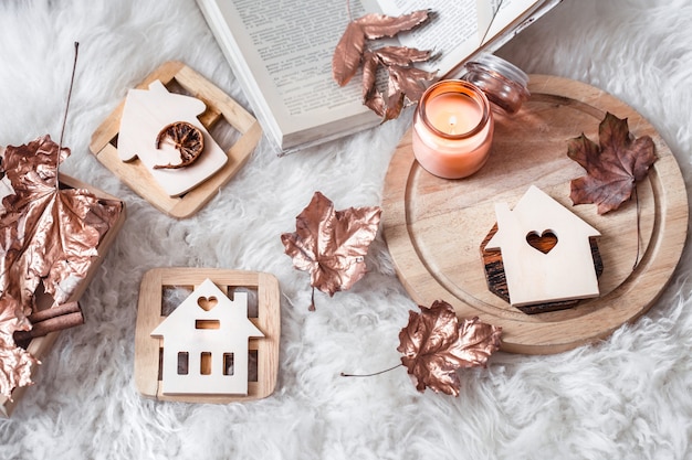 Autumn and winter home still life . The view from the top. Wooden houses with carved heart and autumn Golden leaves.