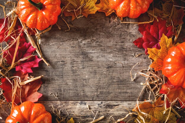     Autumn with yellow and red leaves and pumpkin on wooden table. 