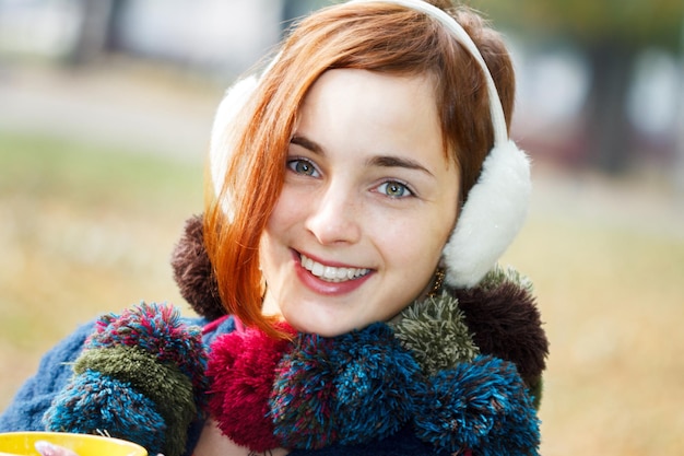 Autumn woman drinking coffee Fall concept of young woman enjoying hot drink from disposable coffee cup in fall landscape Serene happy mixed race Asian Caucasian female model in city forest park