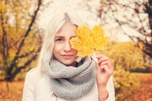 Autumn Woman with Maple Leaf in Fall Park