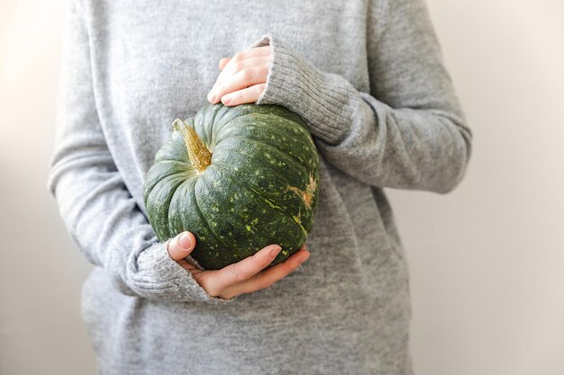 Autumnal background unrecognizable woman holding autumn fall pumpkin in hands isolated on white back