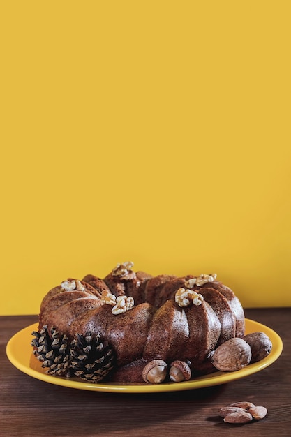 Photo autumnal chocolate cake decorated with pineapples, acorns, walnuts and almonds
