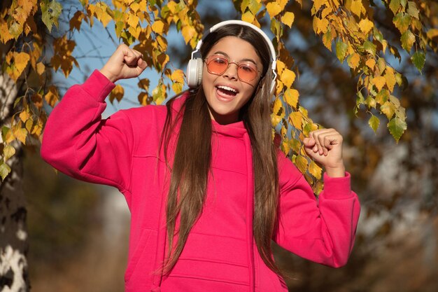 autumnal fall colors Adolescence concept Happy adolescent girl on autumn walk listening music Adolescent girl in fall style girl in music headphones outdoor Hello fall Captivating rhythms