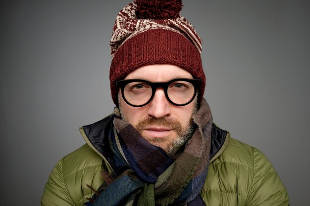 Autumnwinter fashion Attractive man with beard wearing hat and scarf Serious stylish bearded man