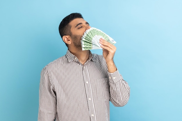 Жадный бизнесмен, нюхающий банкноты евро, наслаждаясь лотереей, выигрывает большую прибыль и богатую жизнь