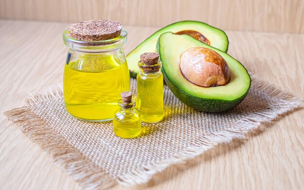 Avocado and avocado oil on wooden background. Selective focus.food