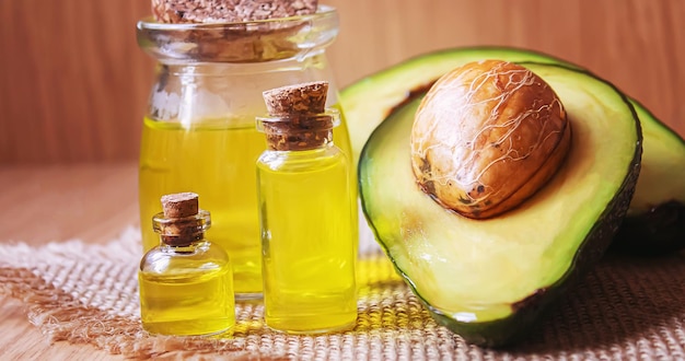 Avocado and avocado oil on wooden background Selective focus