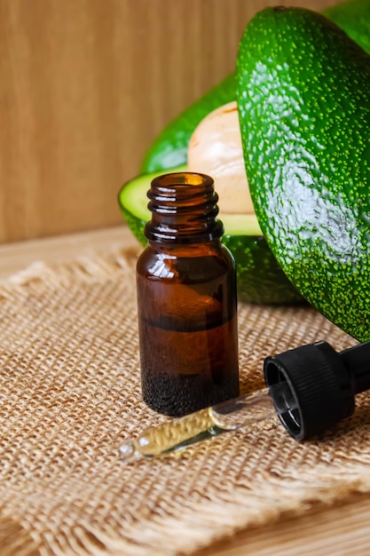 Avocado and avocado oil on wooden background Selective focus