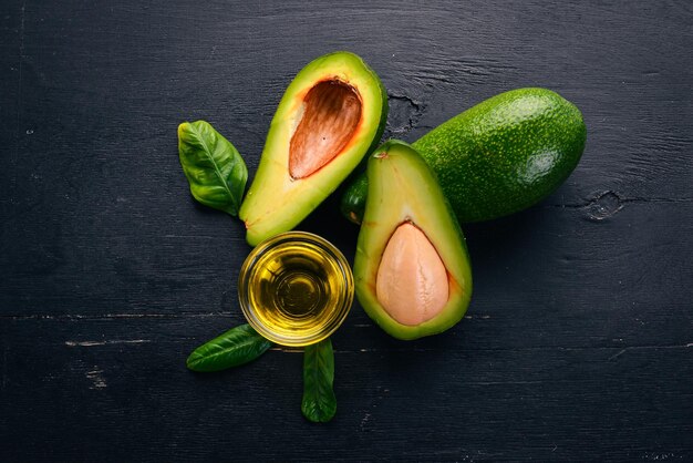 Avocado and avocado oil on a wooden background Top view Free space for your text