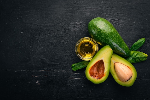 Foto olio di avocado e avocado su fondo di legno vista dall'alto spazio libero per il testo