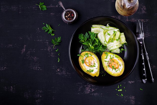 Avocado baked with egg and fresh salad Vegetarian dish Top view overhead Ketogenic diet Keto food