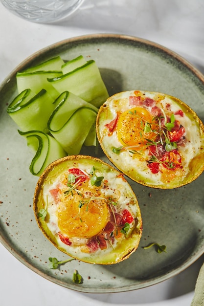 Avocado al forno con uova, prosciutto, pomodori e formaggio, ricetta del pranzo cheto dopo la cottura