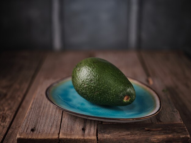 Foto avocado su un piatto blu sul tavolo