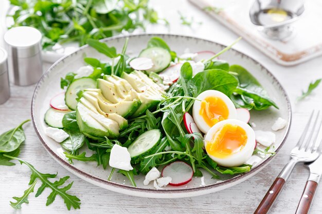 Avocado and boiled egg fresh vegetable salad with radish cucumber spinach arugula and cottage cheese