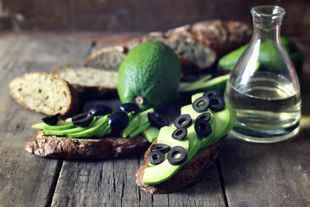 Avocado brood olijven op een houten ondergrond