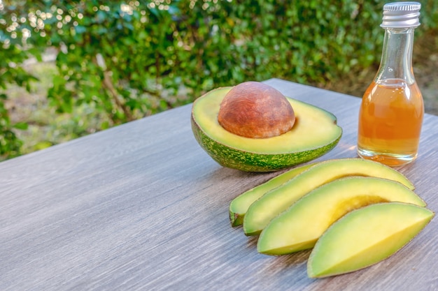 Avocado on a brown wood background and honey on a bottle