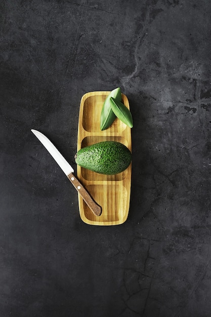 아보카도 요리법. 봉사를 위한 나무 커팅 보드에 익은 녹색 아보카도.