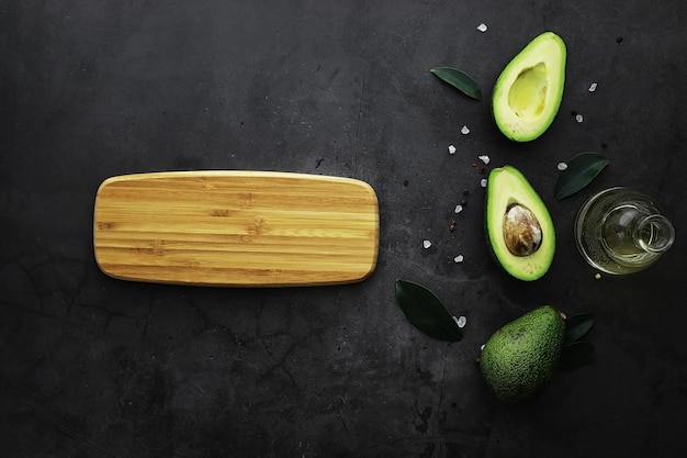 Avocado cooking recipes. Ripe green avocado on a wooden cutting board for serving.