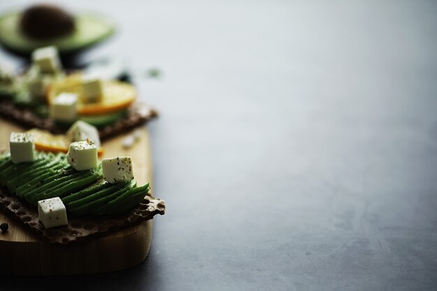 Avocado cooking recipes. Ripe green avocado on a wooden cutting board for serving.