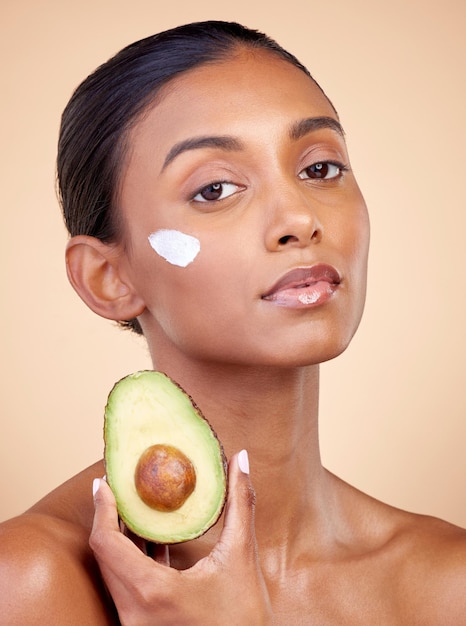 Avocado crème en huidverzorging met portret van vrouw in studio voor product schoonheid en natuurlijke cosmetica Spa gezichtsbehandeling en lotion met gezicht van model op bruine achtergrond voor vitamine c en zelfzorg