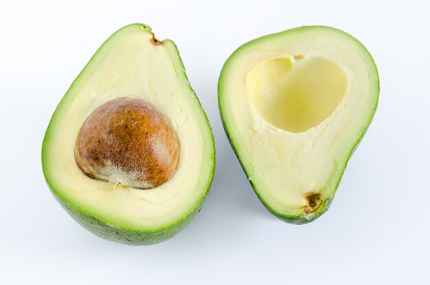 Avocado cut in half on white surface