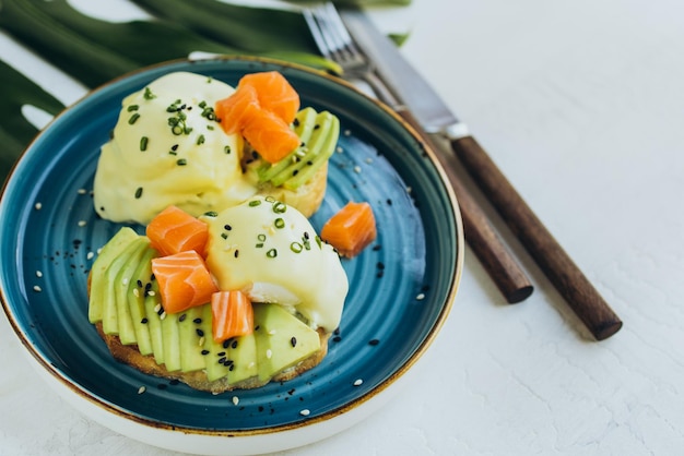 Uovo di avocado e toast al salmone servito su un piatto di ceramica blu