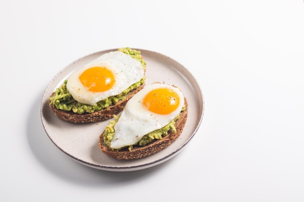 Panino all'uovo di avocado con un bicchiere d'acqua. concetto di sana colazione leggera. toast integrali