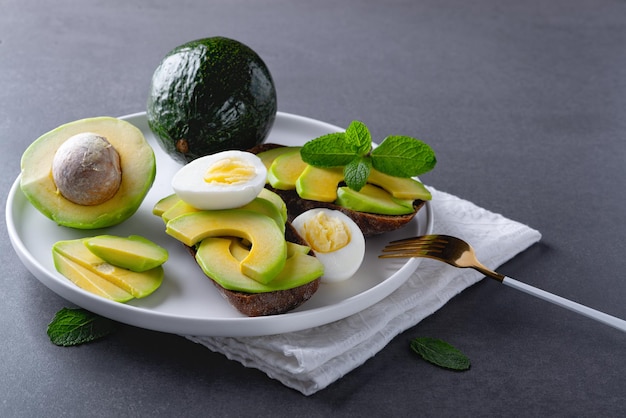 Avocado en ei op donker roggebrood