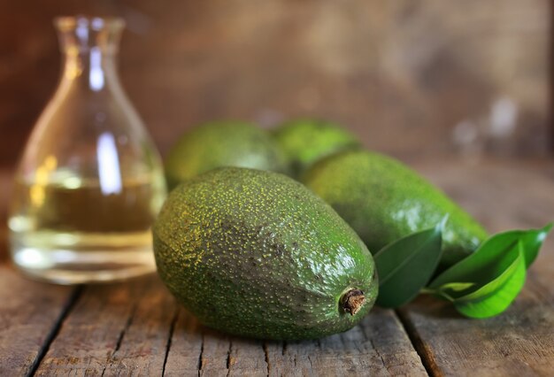 Foto avocado en olie op houten ondergrond