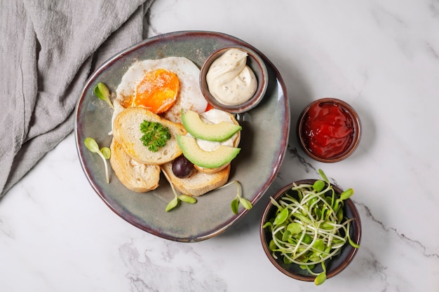 Avocado en sandwich met gebakken ei. Boom gesneden avocado en gebakken ei op geroosterd brood voor het ontbijt.