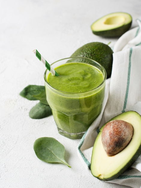 Avocado en spinazie smoothie in glas op witte achtergrond