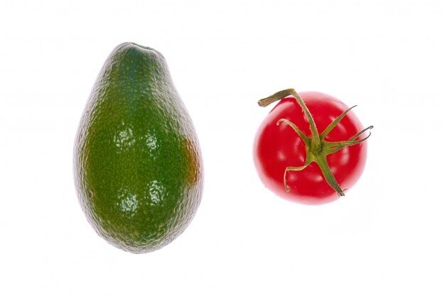 Foto avocado en tomaat die op witte achtergrond wordt geïsoleerd