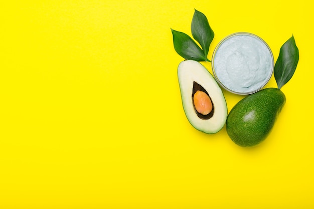 Avocado face mask in glass jar, homemade nourishing mask made from mashed avocado