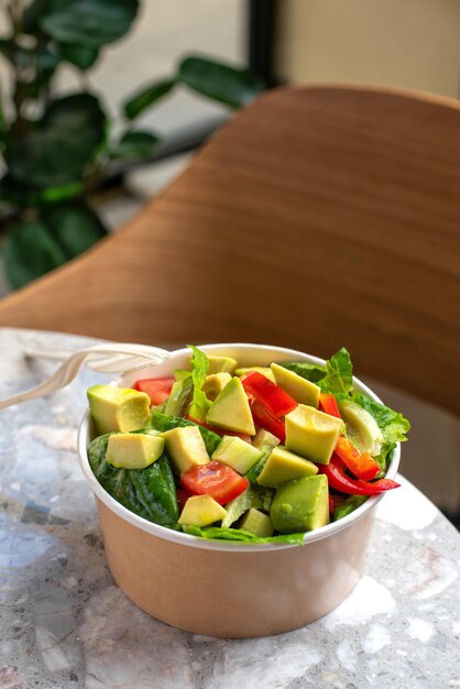 Avocado and fresh tomatoes salad in bowl on gray stone background top view Concept Food For Parties Fast Food