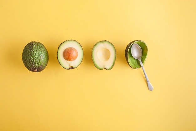 avocado geheel en half op gele achtergrond