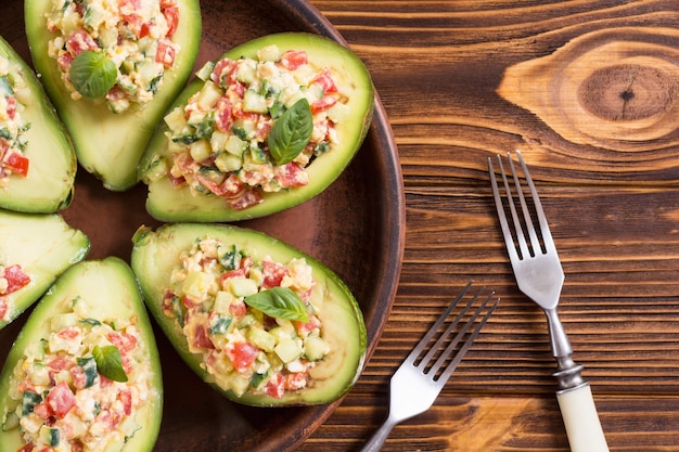 Avocado gevuld met komkommer, tomaten, eieren en basilicum Gezonde voeding