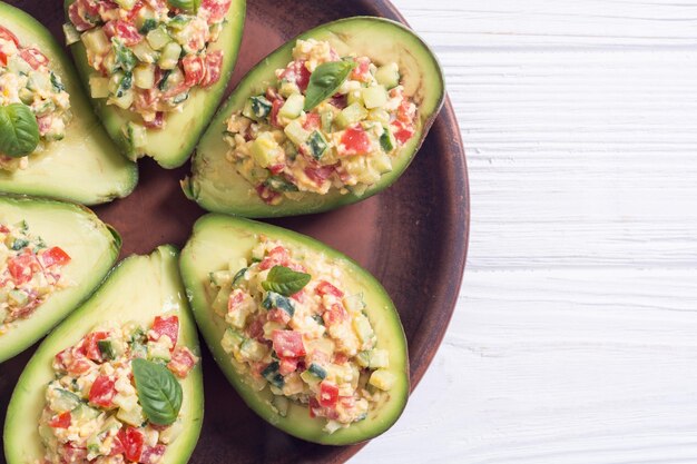 Avocado gevuld met komkommer, tomaten, eieren en basilicum Gezonde voeding